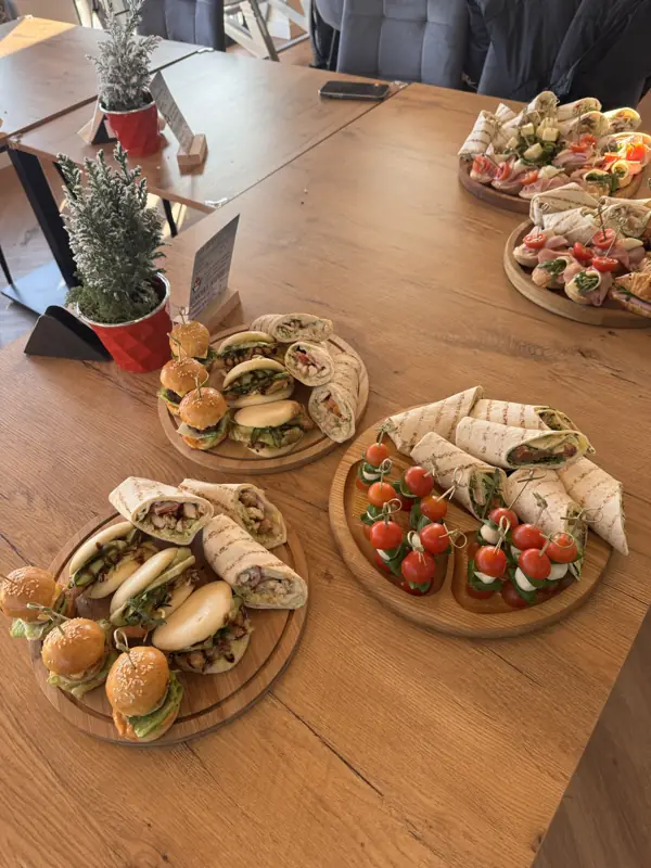 Stół z cateringiem na urodzinach w TILO: deski z tortillami, mini burgerami i koreczkami